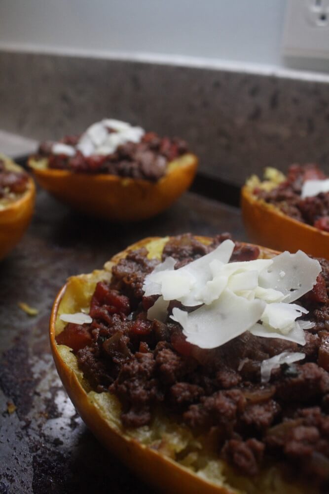 spaghetti squash boats with cheese on baking pan