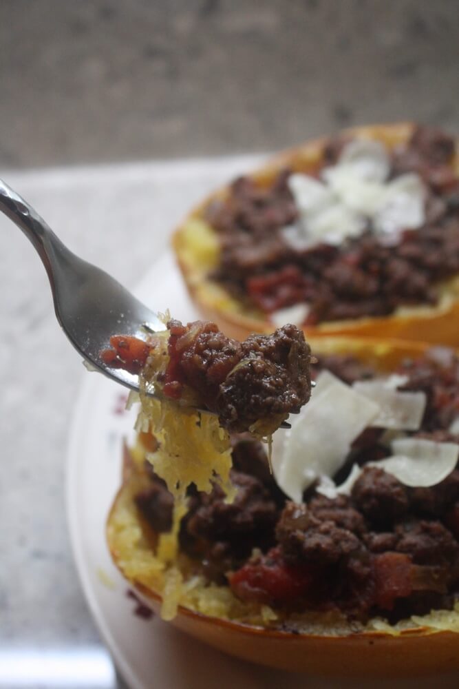 beef and squash on fork in front of spaghetti squash boats