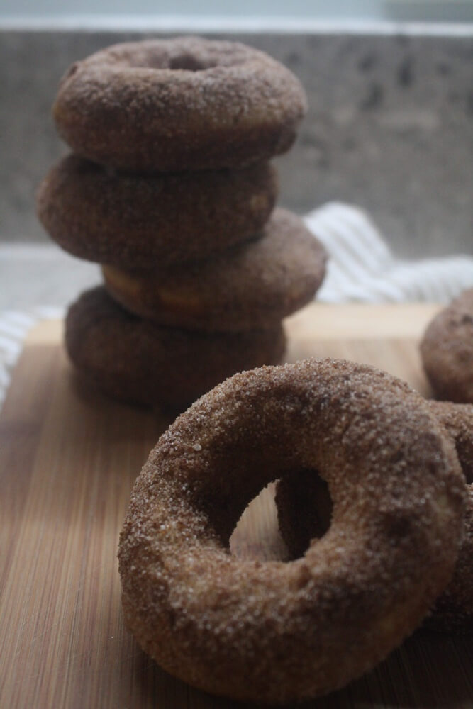 apple cider doughnut propped in front of doughnut stack