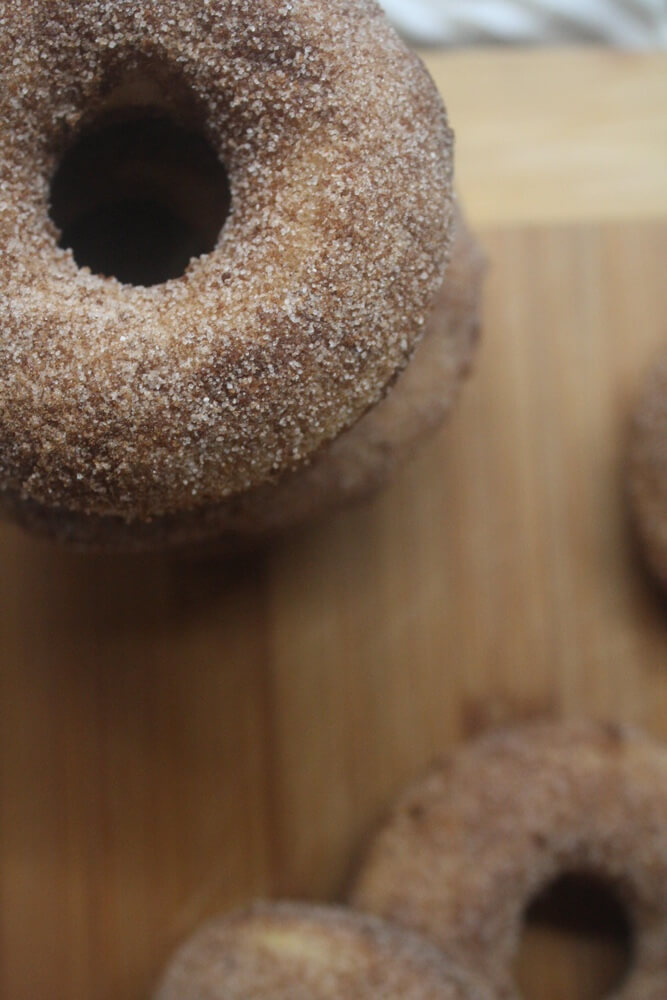 closeup aerial view of apple cider doughnut stack with extra doughnuts in background