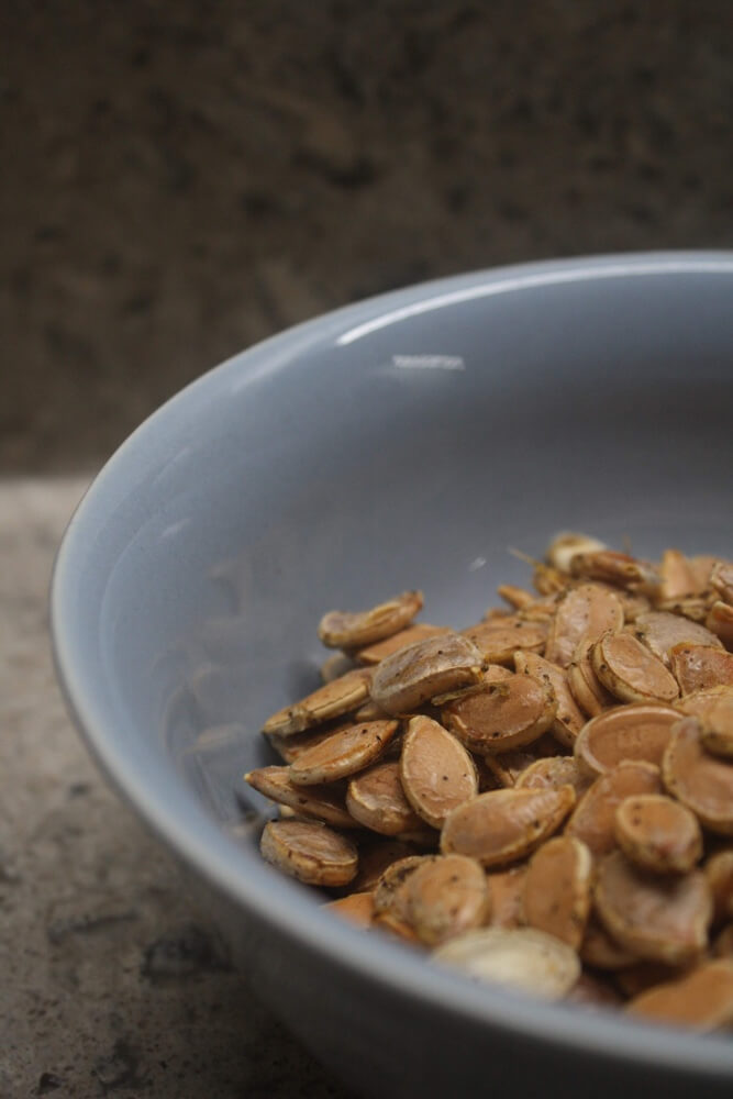 roasted pumpkin seeds in blue bowl