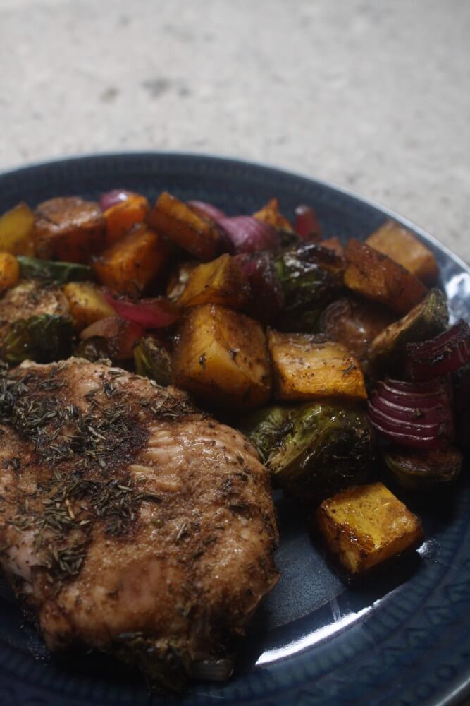 chicken, butternut squash, brussels sprouts, and red onion on a blue plate