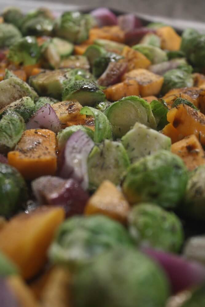 butternut squash, brussels sprouts, and red onion chopped and mixed on sheet pan